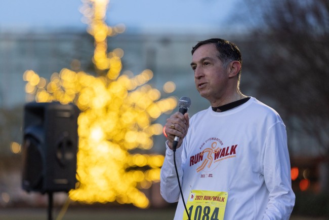 A male runner speaking to the crowd of ASH Foundation Run/Walk
