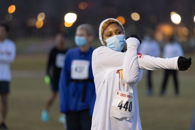 A female runner stretching before the start of the ASH Foundation Run/Walk.