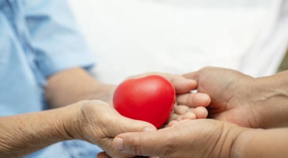 A doctor handing a heart-shaped stress ball to a patient.