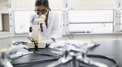 A female researcher looking into a microscope